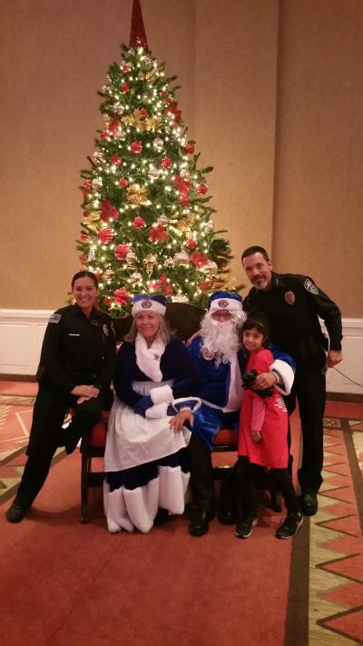 Officers and kids around the Christmas tree